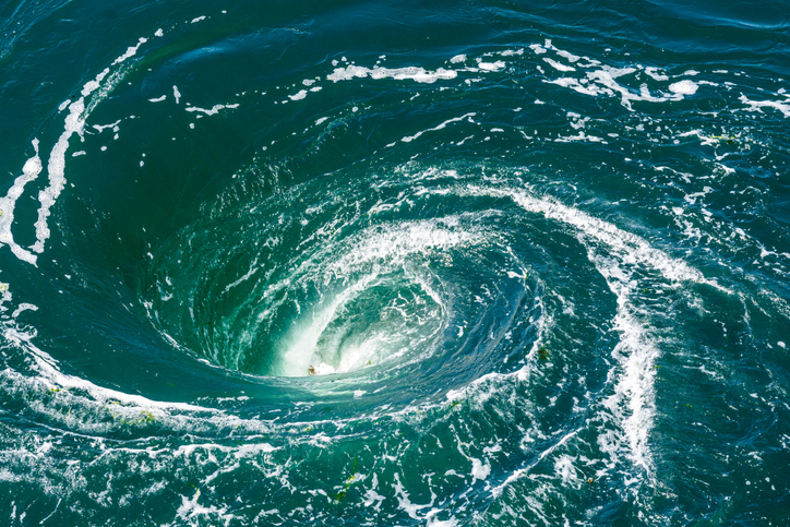 A powerful whirlpool is generated at the surface of the green waters of the river Rance by the action of a turbine of the tidal power station near Saint-Malo in Brittany, France.
